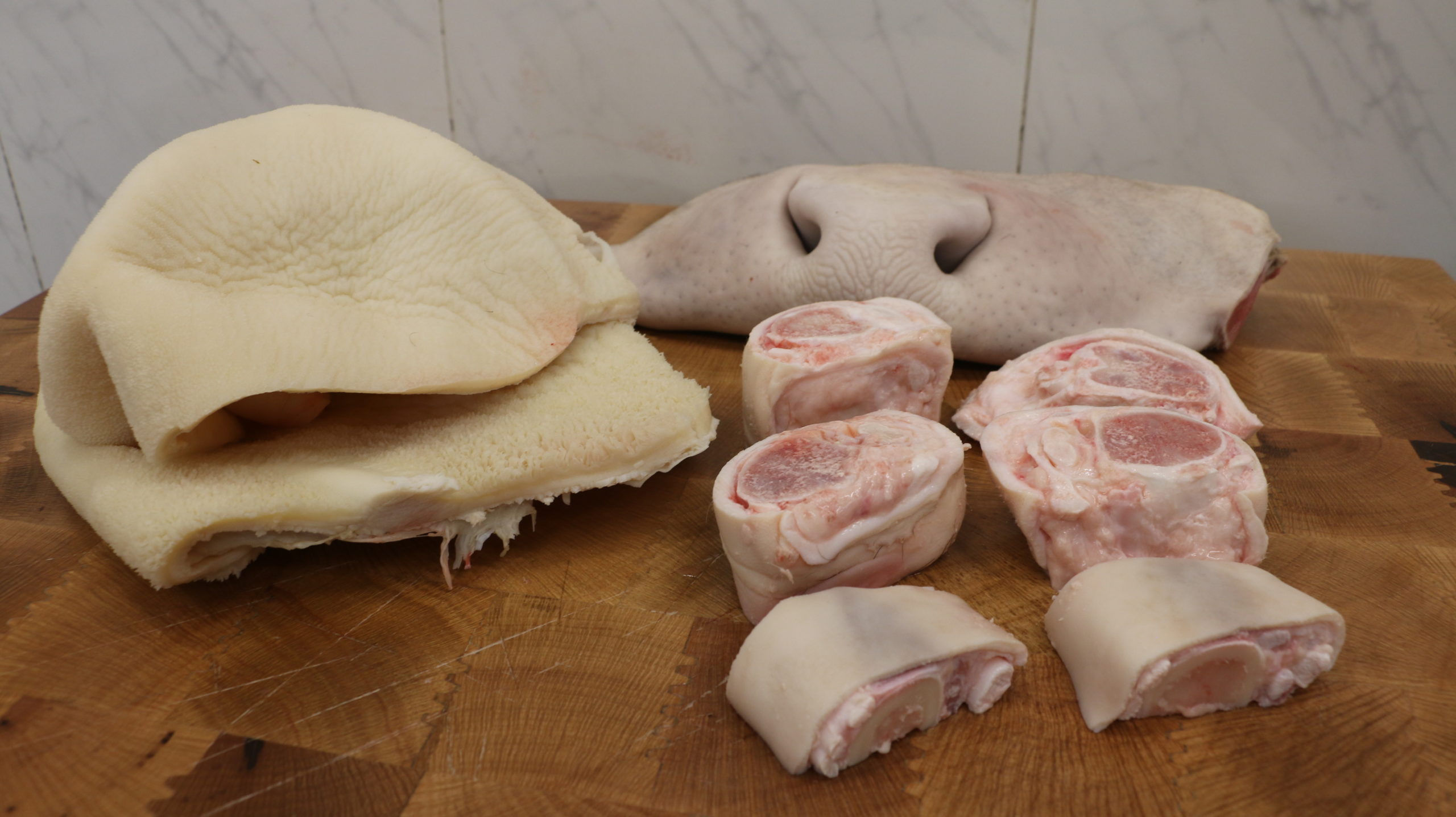 Callos, fociño e pés de tenreira crus sobre unha táboa