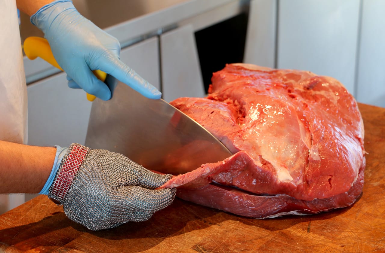 Carniceiro cortando un anaco grande de tapa de tenreira galega