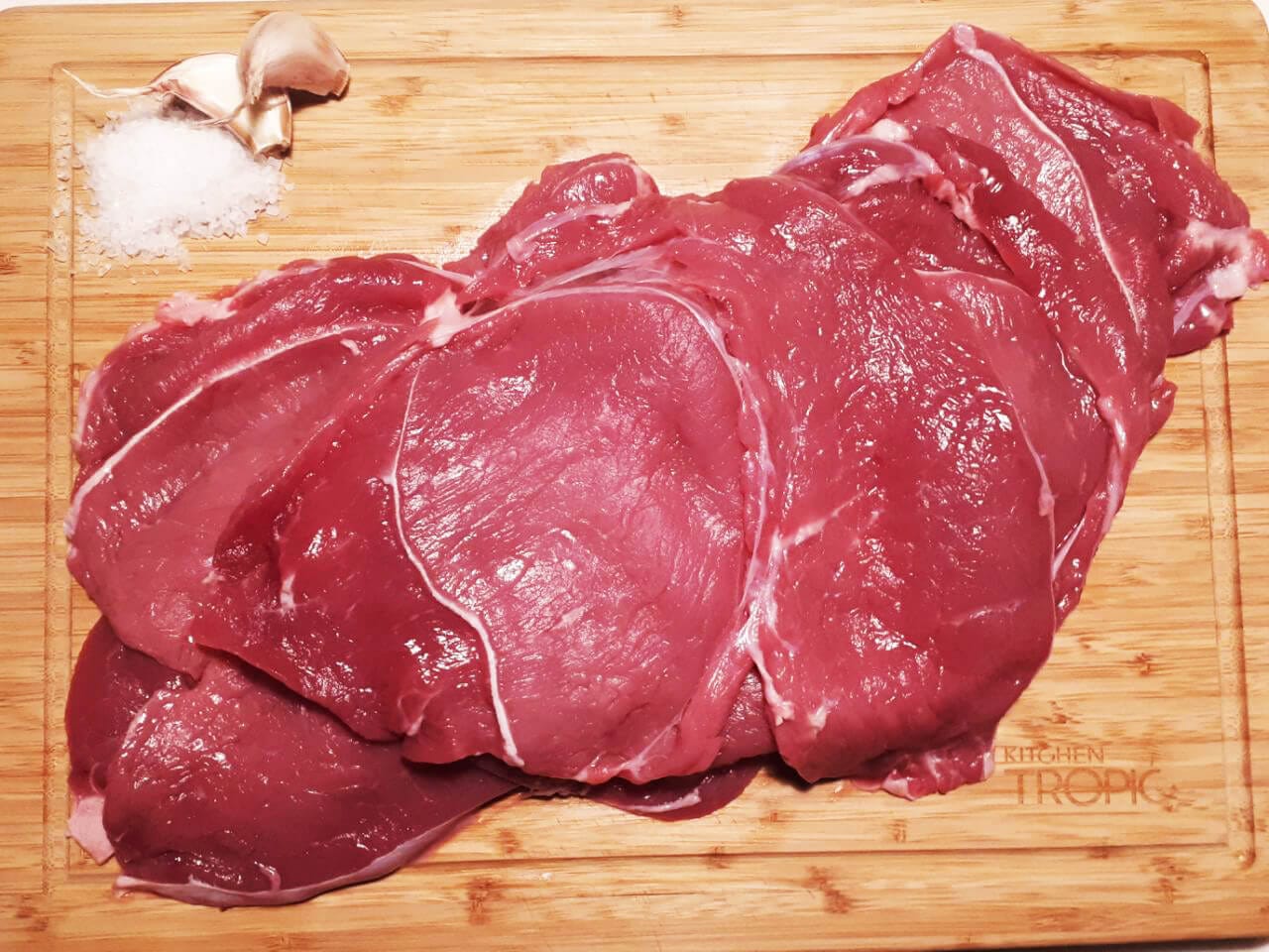 Filetes de tenreira galega crúa nunha táboa con allo e sal