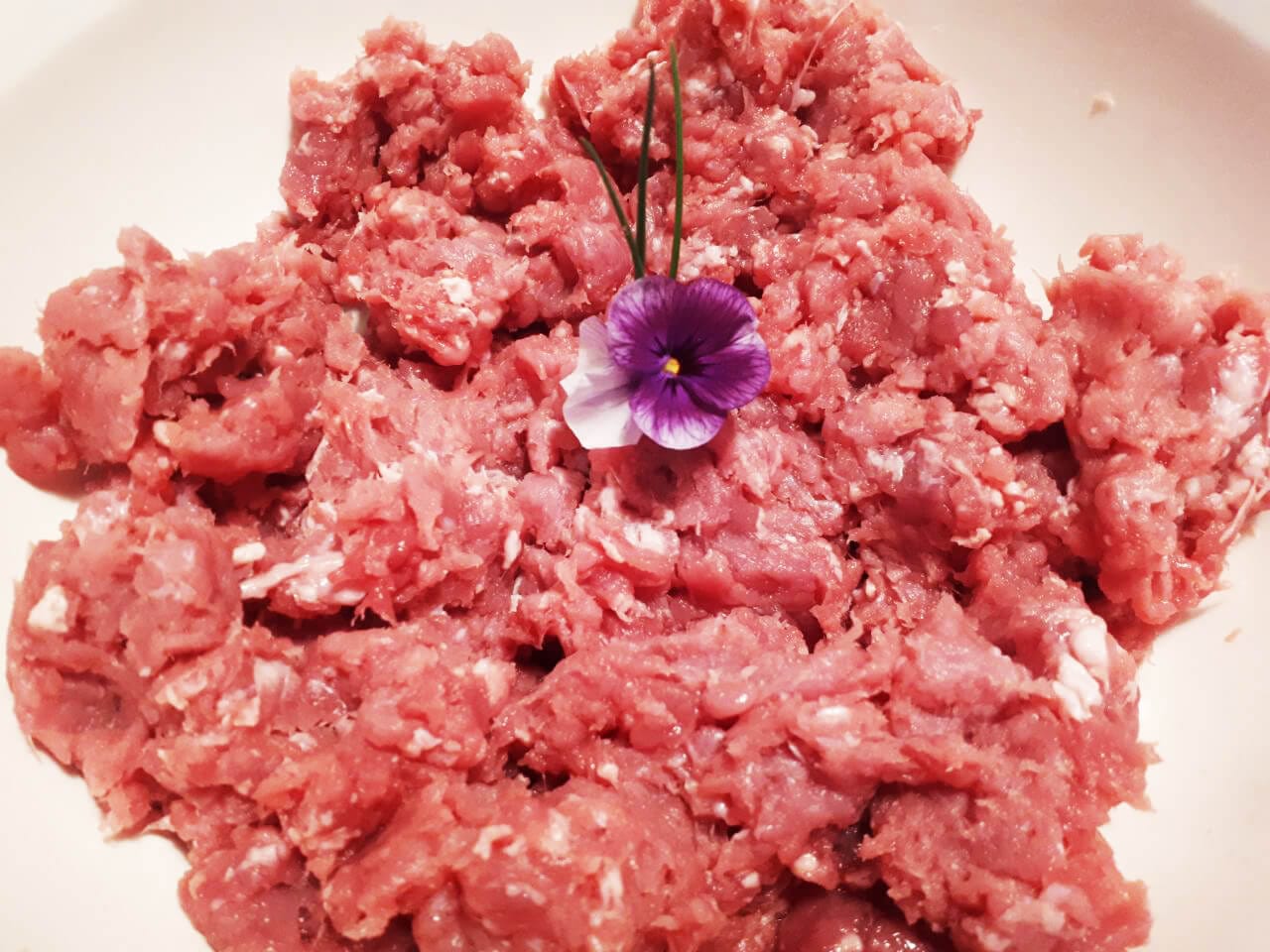 Carne picada de tenreira crúa cunha flor decorativa